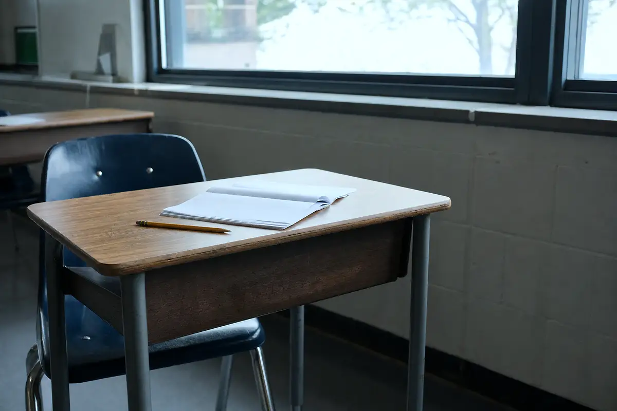 An empty school desk, where new tics are often first noticed.